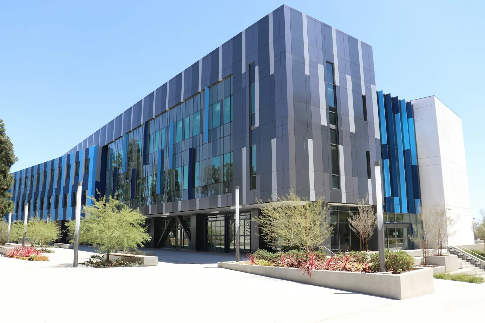 A modern blue-glass office building seen from the pavement