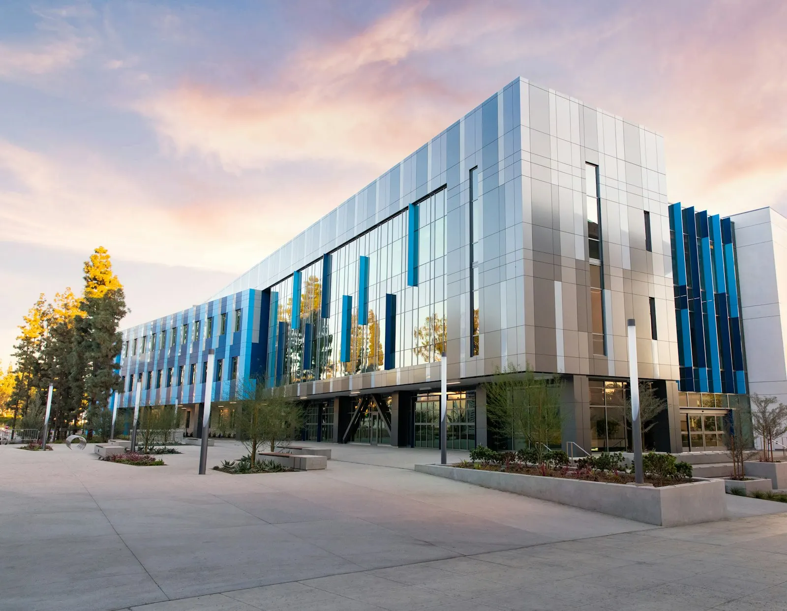 A modern glass-fronted office building photographed at dusk