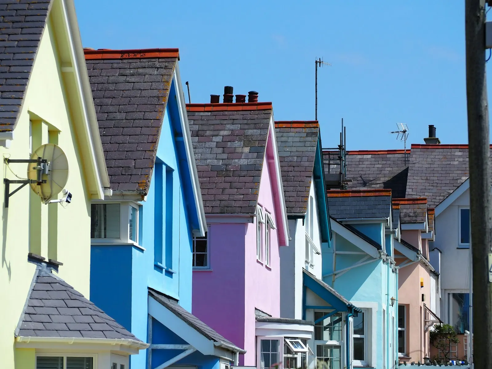 A row of brightly painted terraced houses seen across their rooftops